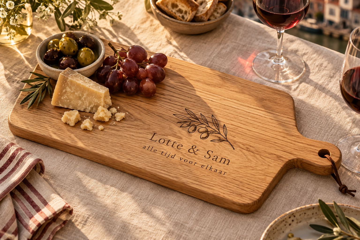 Houten borrelplank met Lotte & Sam erin gegraveerd, met kaas en olijven op een gedekte tafel
